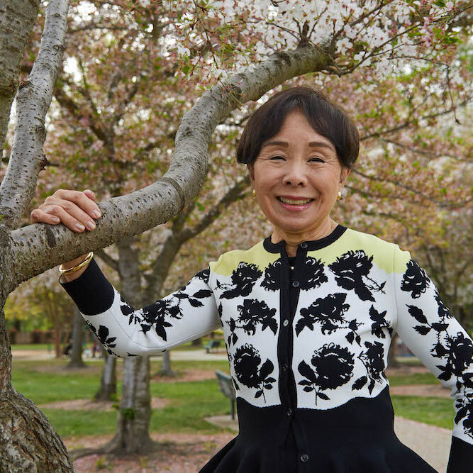Doris Matsui posing with the cherry blossoms